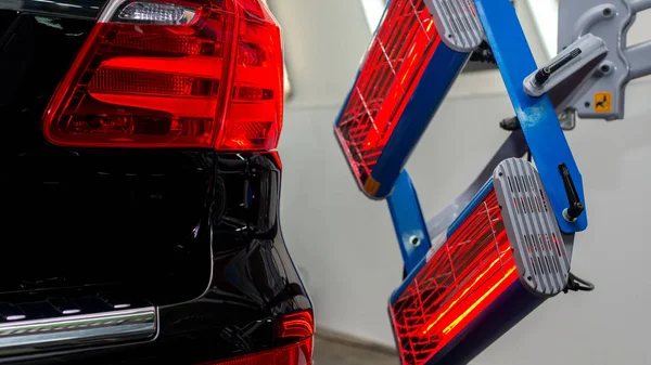 Bir adam siyah bir araba parlatır