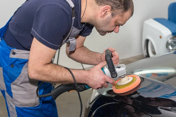 Een Man Polijst Een Zwarte Auto Met Een Polijst Machine — Stockfoto