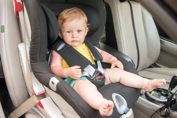 Araba koltuğuna oturan güzel yürümeye başlayan çocuk portresi. Çocuk ulaşım güvenliği