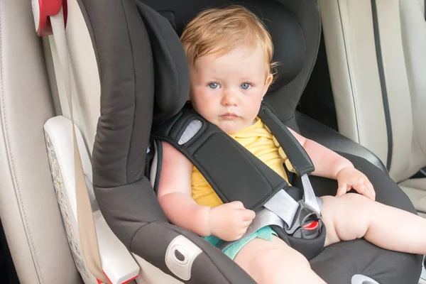 Portrait of pretty toddler boy sitting in car seat. Child transportation safety — Stock Photo, Image