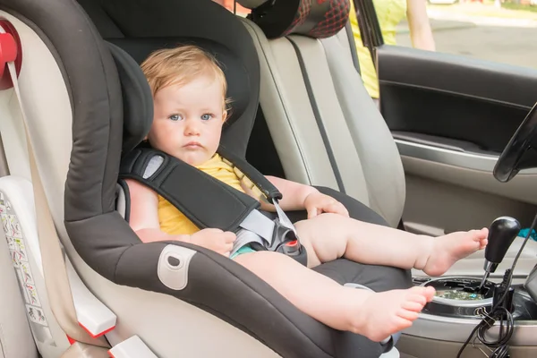 Araba koltuğuna oturan güzel yürümeye başlayan çocuk portresi. Çocuk ulaşım güvenliği