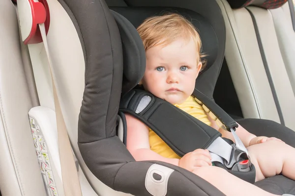 Araba koltuğuna oturan güzel yürümeye başlayan çocuk portresi. Çocuk ulaşım güvenliği