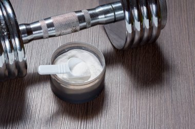 Spor takviyeleri vücut geliştirme için. Protein, bcaa, halter ve arka plan üzerinde