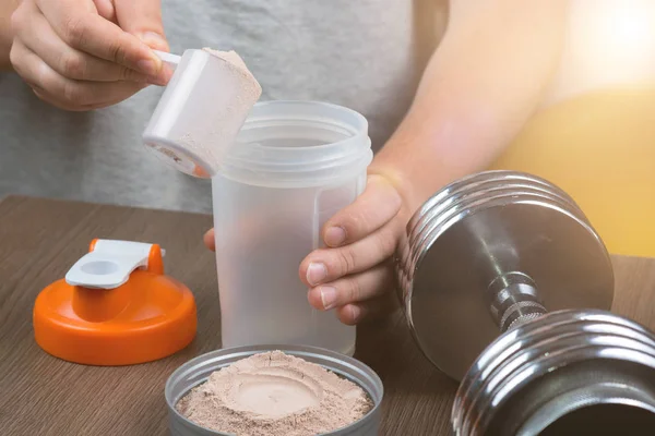Deportes, fitness, hombre preparando un batido de proteínas en una coctelera — Foto de Stock