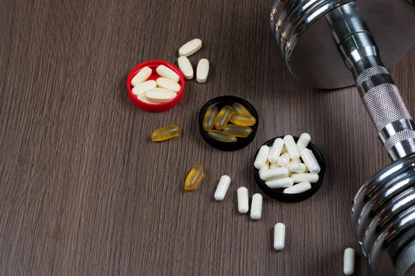 Spor, Fitness, beslenme kapsül ahşap arka plan üzerinde spor