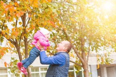 Baba kızıyla parkta oynuyor.