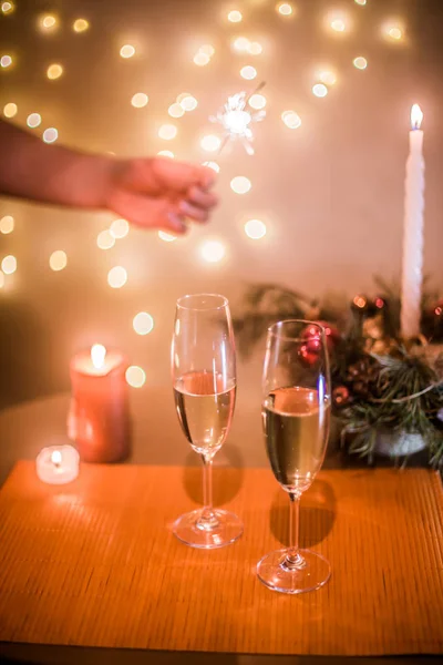 Masadaki Noel şampanyası arka plandaki çelenklere karşı.