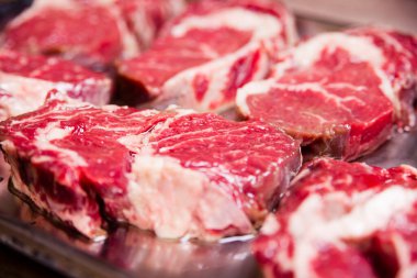 Beyaz arka planda çizgileri olan çiğ kırmızı et. Pişmemiş biftek..