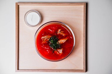 Biftek, ot ve ekşi kremalı Rus çorbası. Yukarıdan manzara. Çorba tabakta servis edilir ve tepsi beyaz arka planda. Üst görünüm.