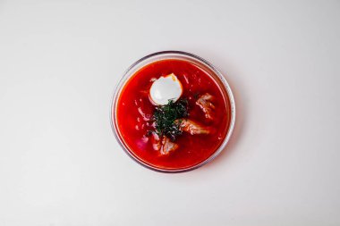 Biftek, ot ve ekşi kremalı Rus çorbası. Yukarıdan manzara. Çorba tabakta servis edilir ve tepsi beyaz arka planda. Üst görünüm.