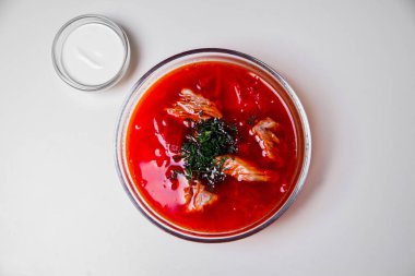 Biftek, ot ve ekşi kremalı Rus çorbası. Yukarıdan manzara. Çorba tabakta servis edilir ve tepsi beyaz arka planda. Üst görünüm.