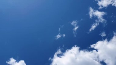 Düşük açılı bulutlu zaman akışı. Mavi gökyüzünde hareket eden tüylü bulutlar. Hava bileşimi, rüzgarın esintisi değişen sis şekilleri, soyut doku..
