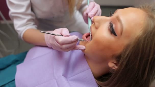 Ženský lékař zkoumá mladé dívky zubů v zubní ordinaci.