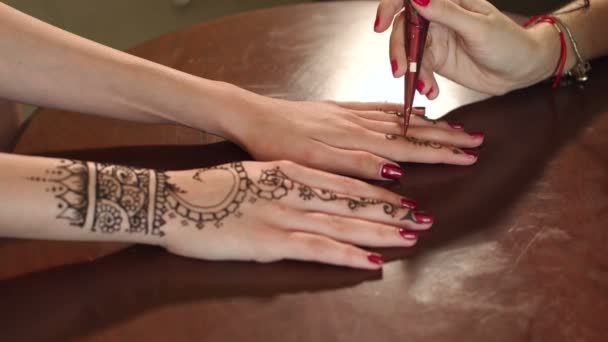 Žena dělat henna tetování na ruce, detail.