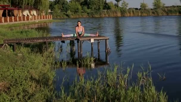 Woman doing yoga stretching exercise outdoors. — Stock Footage Woman doing yoga stretching exercise outdoors. Royalty Free Stock Footage