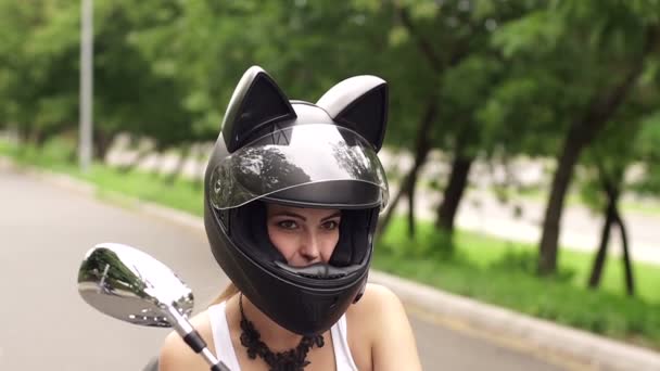 Fille Assise Sur La Moto Dans Un Casque Avec Oreilles De Chat