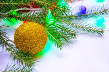 Yeni yıl ağacının dalları Noel oyuncakları ve beyaz arka planda çok renkli ampulleri olan çelenkler. 
