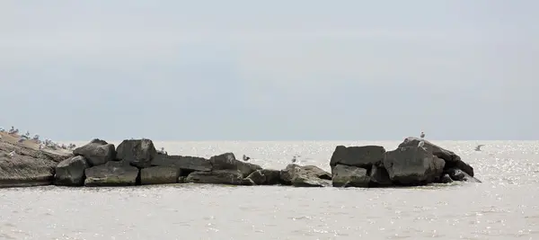 Mur de rupture de roche à côté d'une jetée en béton — Photo