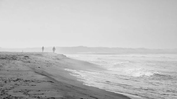 Σκηνή παραλίας σε μαύρο και άσπρο με ομίχλη και οι άνθρωποι — Φωτογραφία Αρχείου