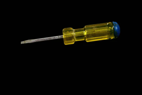 Screwdriver with a yellow and blue handle isolated on a black background — Stock Photo, Image