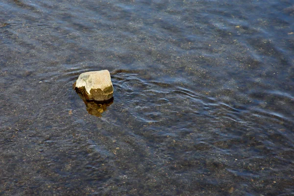 Tiszta víz folyik körül egy nagy szikla — Stock Fotó