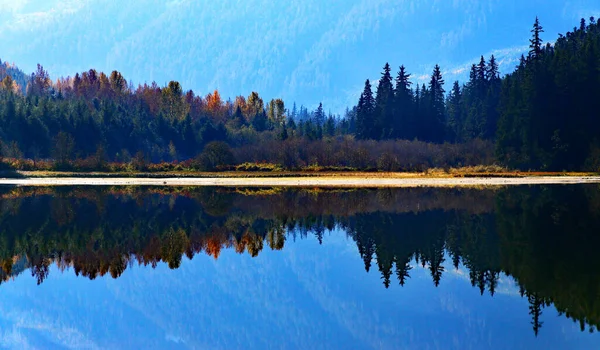 Lago com floresta de outono refletida na água — Fotografia de Stock