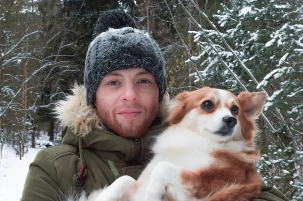 Un hombre con un perro en el bosque de invierno —  Fotos de Stock