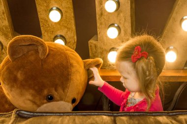 bir oyuncak ayı bir stüdyo fotoğraf çekimi ile oynayan kız