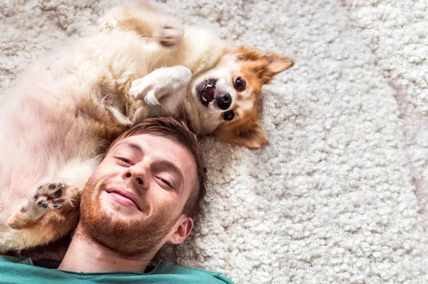genç adam bir köpek ile oynanır. portre kadar kapatın