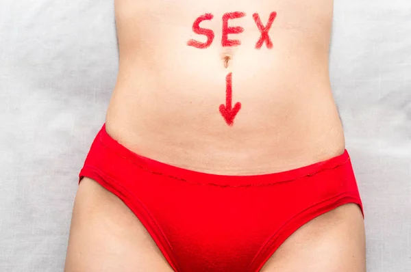 Pojęcie seksu i związków. słowo seks i Strzałka w dół na brzuch kobiety z szminki — Zdjęcie stockowe