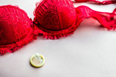 Kırmızı iç çamaşırı ve açık bir prezervatif. kavram seks. cinsel enfeksiyondan korunma