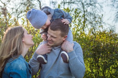parkta bir yürüyüş üzerinde mutlu bir aile. Baba, anne ve oğlu