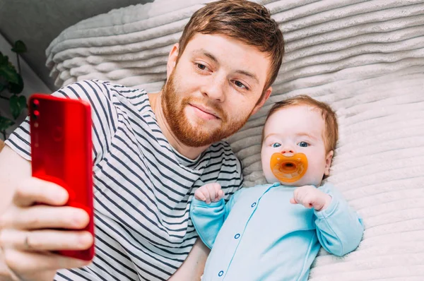 Hombre, niño tomar una selfie en la cama — Foto de Stock