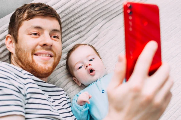 Papá y el bebé se toman una selfie por teléfono. Retrato de primer plano — Foto de Stock