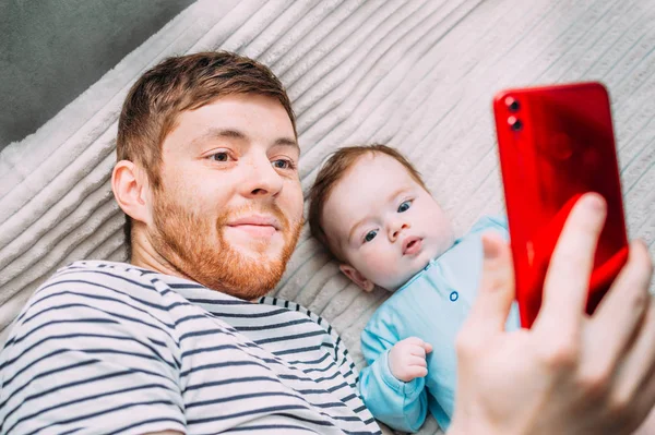 Papá e hijo se hacen una selfie por teléfono. Retrato de primer plano — Foto de Stock