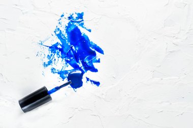 Beyaz arka planda mavi oje. Klasik mavi renk modası. Vernik lekeleri. Püskürt