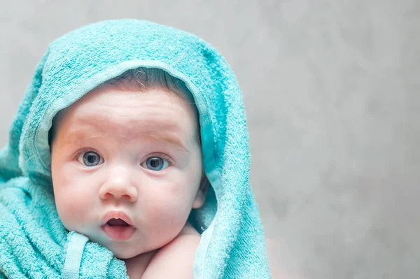 Retrato de primer plano de un bebé en una toalla después de bañarse. Concepto de cuidado del bebé — Foto de Stock