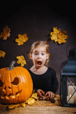 Kız Halloween kabak ile poz veriyor.