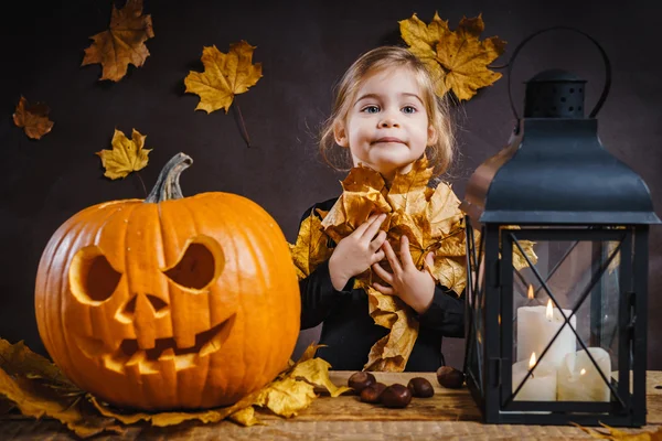 Kız Halloween kabak ile poz veriyor.