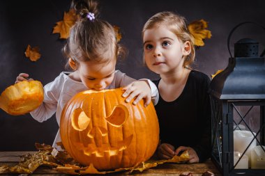 İki kız bir Halloween kabak ile oynamak