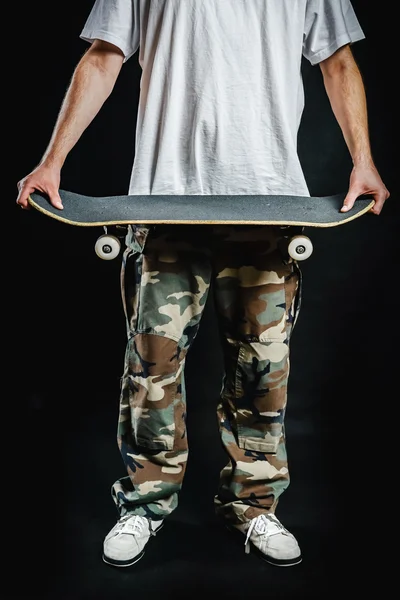 man holding a skateboard in his hands