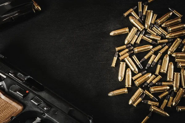 Пистолет и пули на столе — стоковое фото