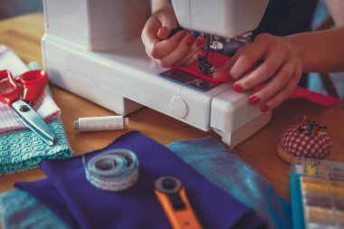 kadın bir dikiş makinesi çalışıyor