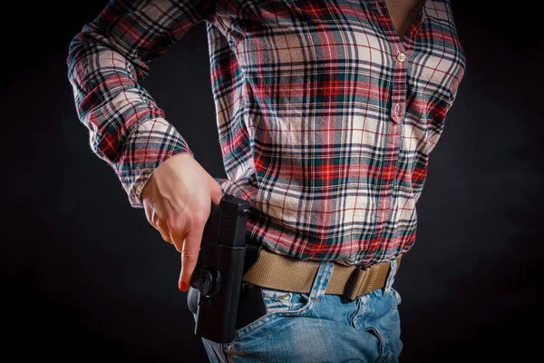 Vrouw neemt een pistool uit de holster — Stockfoto