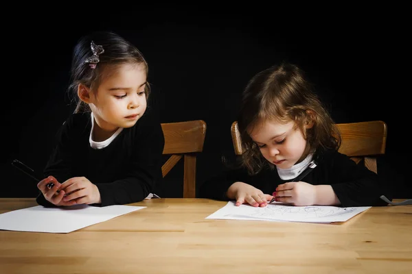 Zwei kleine Schwestern zeichnen auf Zetteln — Stockfoto