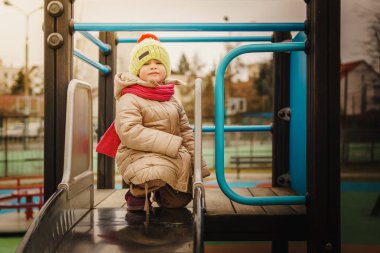 küçük kız bir slayt üzerinde duruyor