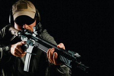 saldırı tüfeği tutan şapkalı adam