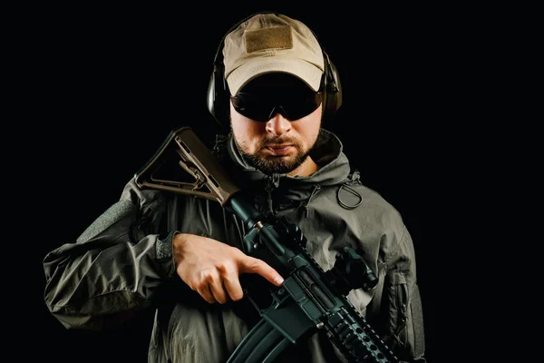 Homem em cap segurando rifle assalto — Fotografia de Stock