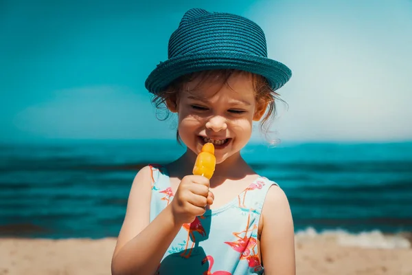 Küçük ve şirin kız sahilde dondurma yeme — Stok fotoğraf