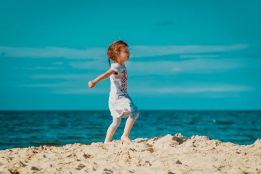 Küçük şirin kız sahilde yürüyor